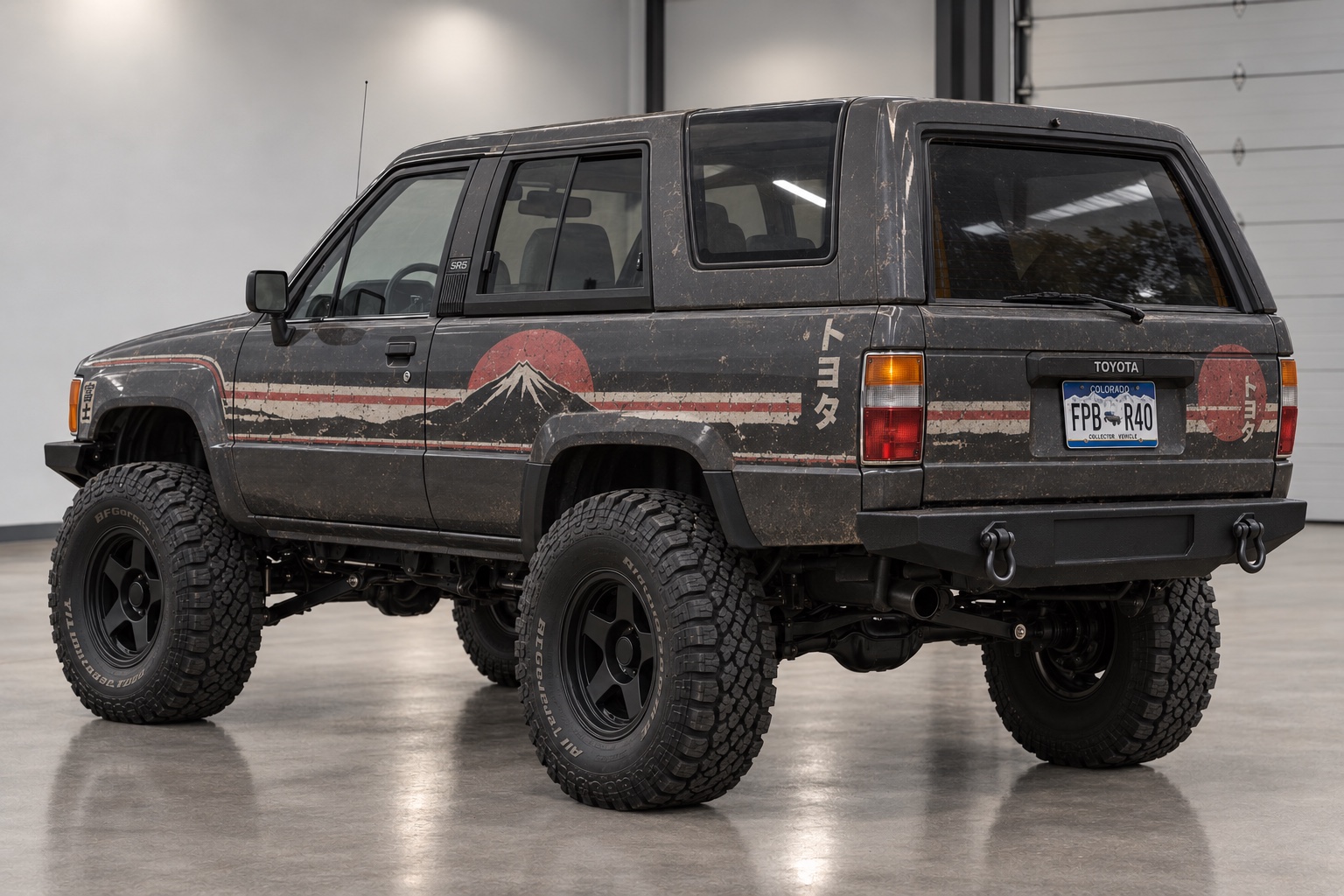 The 4Runner from the rear three quarter, showing the Fuji stripe wrapping the rear quarter, katakana lettering and the steel rear bumper with recovery shackles